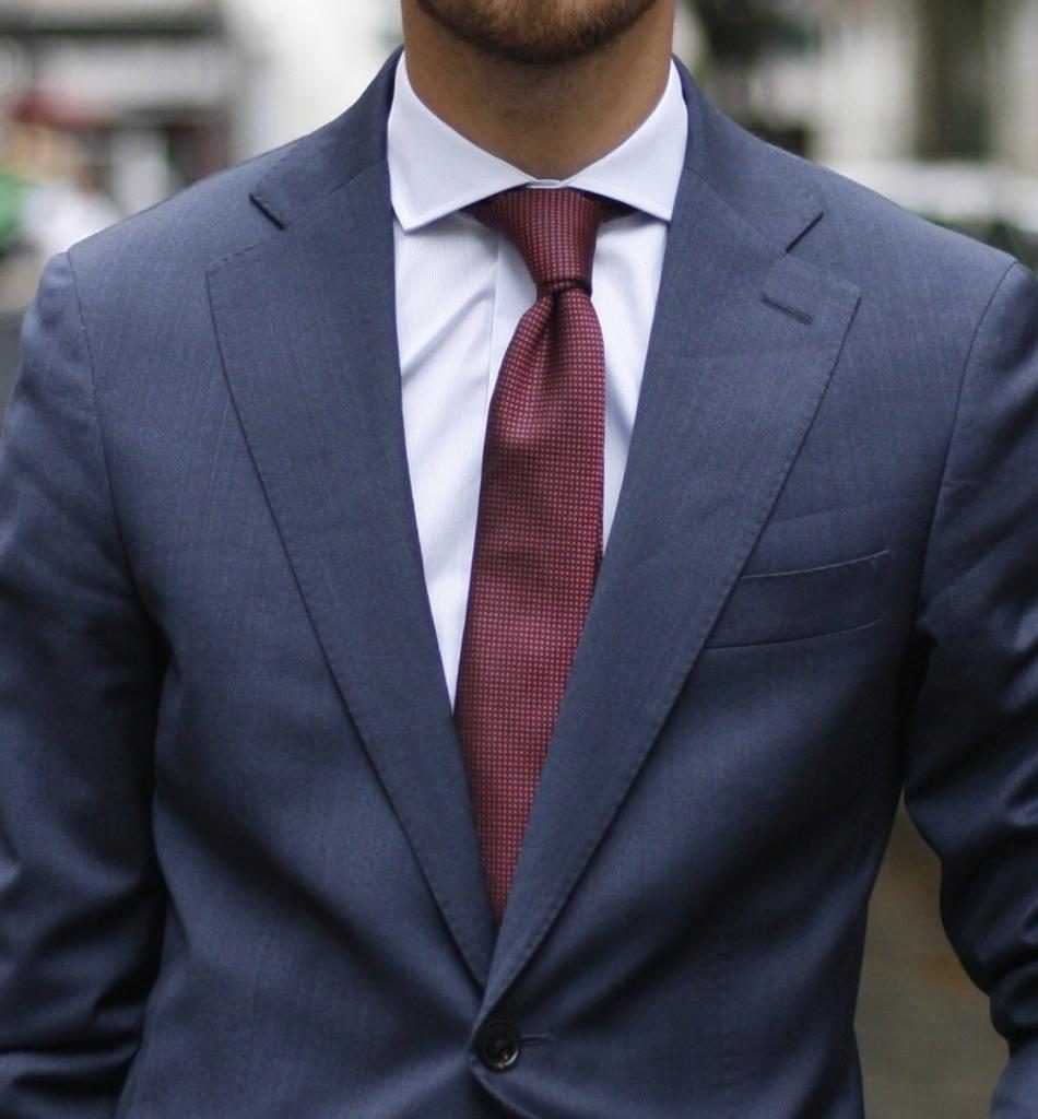 Uomo in giacca blue e camicia bianca con cravatta bordeaux