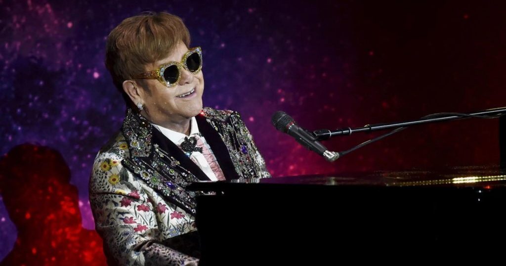 Elton John che canta mentre suona il piano